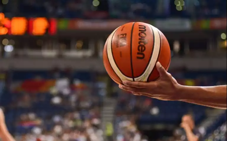 A ref holding a basketball NBA draft 2024