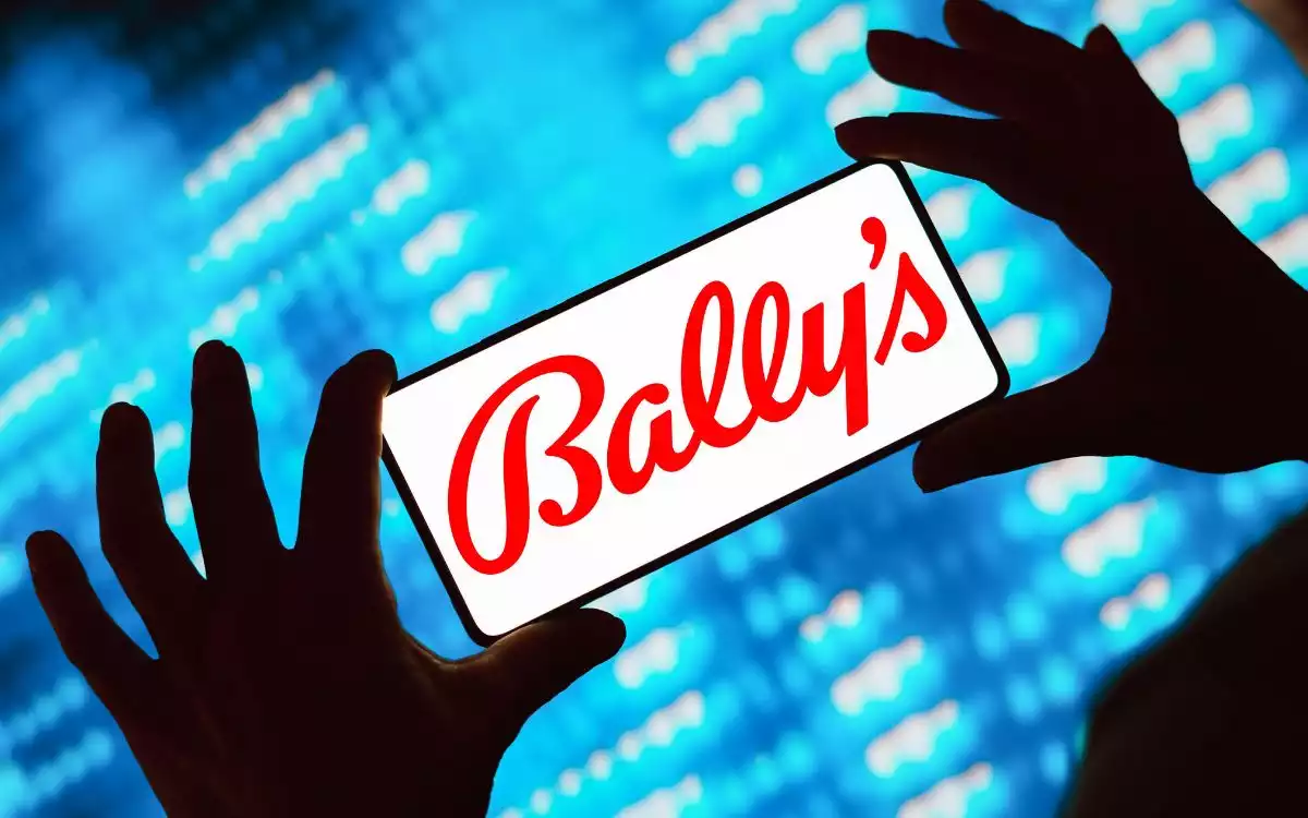 Hands holding a mobile phone with Bally's Logo