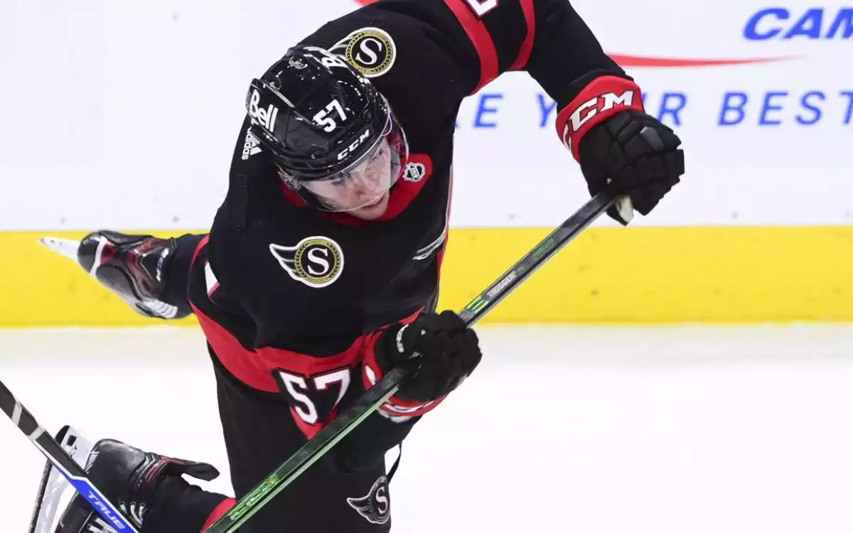 Shane Pinto of the Ottawa Senators falling down on the ice