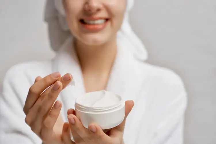 young woman close-up holding moisturizer