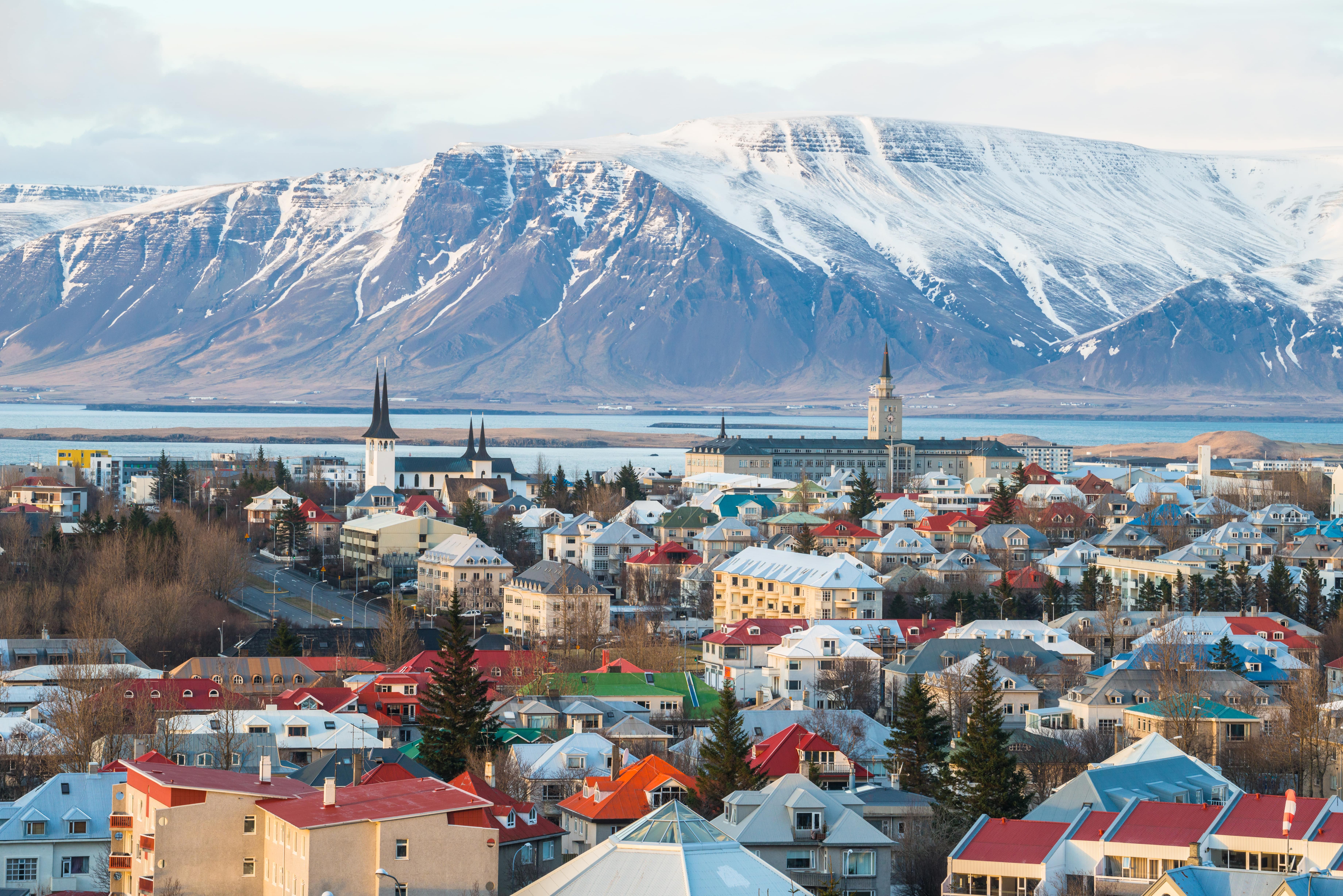 Picture of mountains in Iceland with colourful houses and a town in the foreground